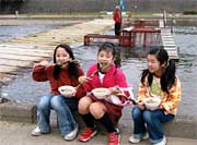 加茂川を上ぼるサケを捕まえるウライを背に「いただきまーす!」