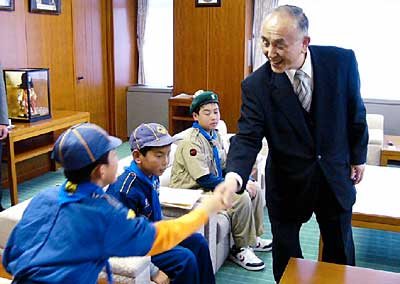 募金を赤い羽根共同募金に寄付したボーイスカウト加茂第1団の団員と握手する小池加茂市長