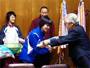 選手にコメや洋ナシを手渡す小川JAにいがた南蒲組合長(いちばん右)