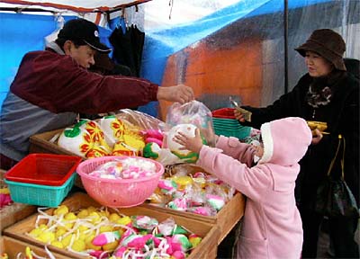 7日、三条市の二七の定期市で繭玉飾りを売っていた白根市の遠藤さん