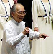 演奏前に曲を紹介する東京混声合唱団の田中桂冠指揮者