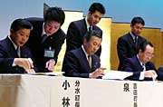合併協定書に調印する左から小林分水町長、泉吉田町長、高橋燕市長