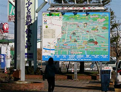 新三条市の図案に張り替え作業中のJR燕三条駅前の大型看板