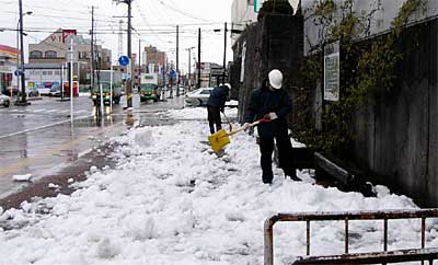 三条市役所わきの残雪を崩して広げ、雪解けを早める作業