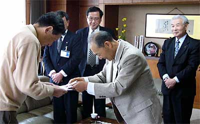 高橋三条市長(手前左)に10万円の寄付を手渡す斉藤三条市音楽協会会長(手前右)