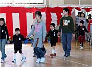 上級生に手を引かれて入場する1年生