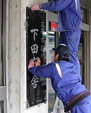 新しい「三条市役所　下田庁舎」の銘板を取りつけて完成