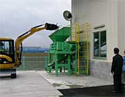 せん定枝を破砕機へ入れる