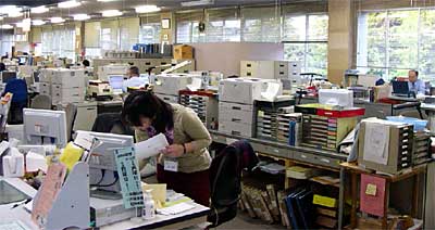 勤務時間後も情報システムの動作確認のために待機する三条市役所市民課職員