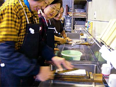 三条鍛冶道場の包丁研ぎ体験教室に参加して包丁を研ぐ主婦