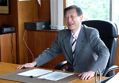 市長室で旧栄町役場から移設したいすに座る高橋市長