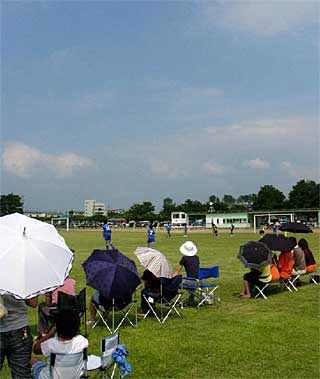 30日、炎天下で三条・燕総合グラウンドで行われた三条市サッカー大会に咲く日傘