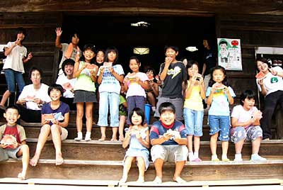 福勝寺の夏休み子ども会で、本堂前でスイカの種飛ばしをする子どもたち