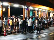 にわか雨でアーケード下に会場を移してビンゴ大会を行う一ノ木戸商店街