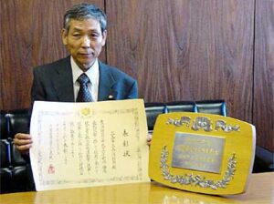 内閣総理大臣表彰の表彰状と盾を前に関山三条消防団長