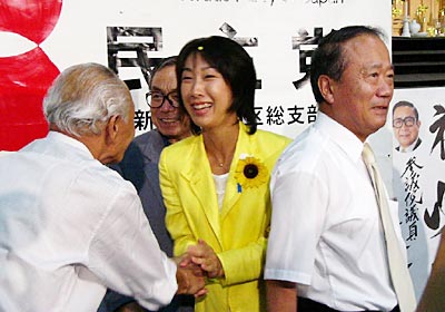 当選確実の知らせに運動員や支持者と握手する菊田氏