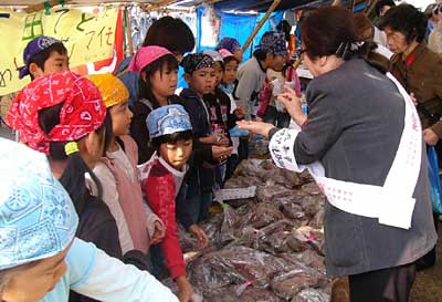 27日、三条市の二七の定期市でサツマイモを販売する飯田小3年生