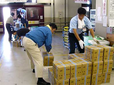 三条郵便局でトラックからお年玉付き年賀はがきを局内に運び入れる職員