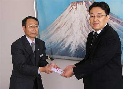 関口芳史収入役(右)に善意を包んだのし袋を手渡す児玉北陸瓦斯(株)長岡支社次長(左)