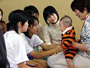 恐る恐る赤ちゃんを抱っこする中学生の女の子