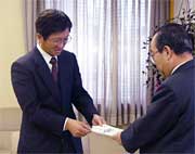 高橋燕市長に寄付の目録を手渡す高山さん
