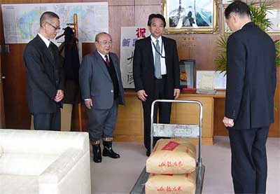 寄付したもち米60キロと左から金子いからしの里園長、嵐県議、土田大島電機社長、高橋市長