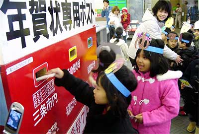 15日、三条郵便局で行われた年賀状差出式で専用ポストに年賀状を入れる宝塔院幼稚園年長児