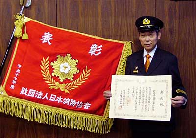 三条市三条消防団がうけた表彰旗と関山一雄団長
