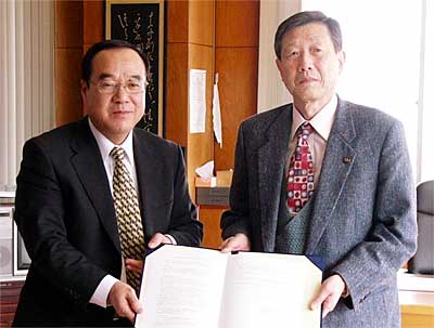 災害時用の自販機設置などで協定し、協定書を見せる続麻信越ペプシコーラ販売社長(左)と高橋三条市長(右)