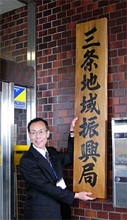 旧三条総合庁舎に「三条地域振興局」とある銘板を掲げる堀局長