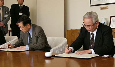 レンタル機材の供給に関する協定の調印書に署名する高橋三条市長(左)と高屋コーエイ社長(右)