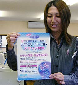 ヒメサユリ写真・絵画コンテストのちらしを手に日の丸観光タクシースタッフ