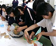 授業の一環で会場で土器の復元体験に挑戦する地元下田中の2年生