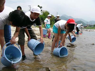 五十嵐川漁業協同組合が五十嵐川で小学生によるアユの放流