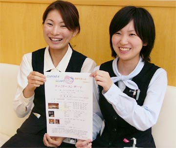 ファミリーコンサートのちらしを手に茅原クリニックのスタッフキャプション