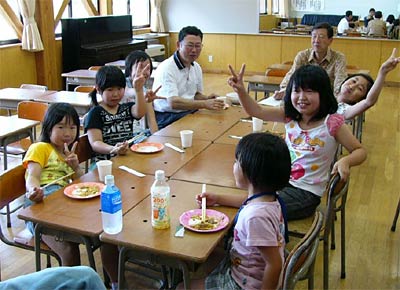 24日行われた月岡小学校区の地域子どもふれあい教室で高橋市長(奥)と席を並べて焼きそばを食べる児童