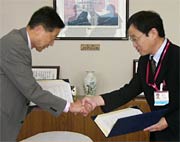 調印後、握手する高橋市長と菅原店長