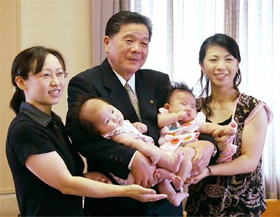 小林市長(中央)に赤ちゃんを抱いてもらって記念撮影の玉木さん(左)と渋木さん(右)