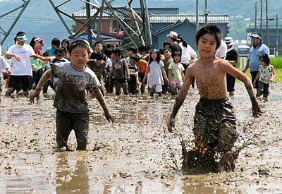 5日、三条市西大崎地内の泥田にした休耕田で行われた「どろんこフェスティバル」