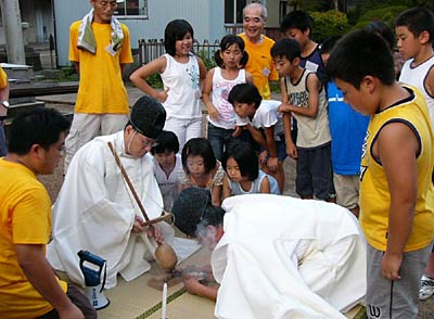 三条市・神明宮で行われた県神社庁など主催庭燎の集いで子どもたちに囲まれて火おこしの儀に汗を流す宮司