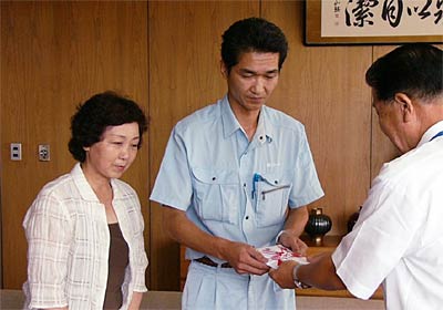 左から故竹越孝雄さんの妻幸さん、長男孝行さん、小林燕市長