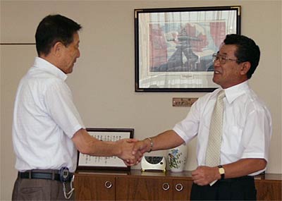 災害時における物資供給に関する協定に調印し、握手する高橋三条市長(左)と坂本アークランドサカモト会長(右)