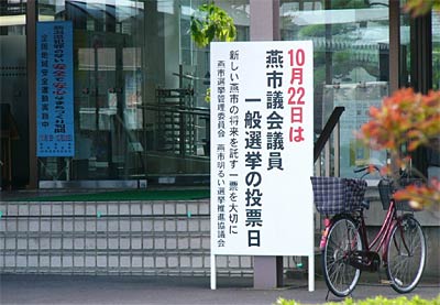 燕市議選の啓発看板が設置された吉田庁舎正面玄関前