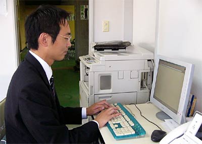 後援会事務所でパソコンに向かう国定氏