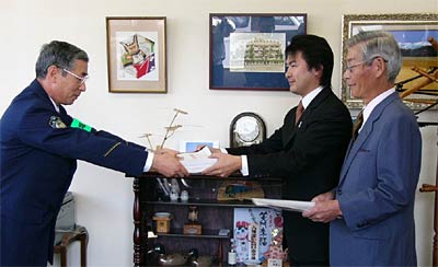 猪股三条署長(左)に署名簿を手渡す渡辺マルソー(株)社長(右奥)と高橋三栄実業(株)社長(右手前)