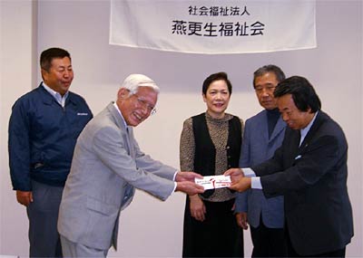 (社)燕更生福祉会の岡田理事長に20万円の寄付を手渡す県燕理容組合の田中理事長