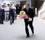 花束を手に職員の拍手に送られる