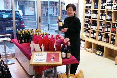 16日解禁のボージョレ・ヌーボーを赤い袋に入れて予約客を待つカブミサキヤのコンセイエ、高橋さん
