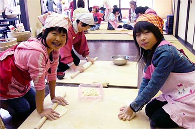 25日行われた三条市下田公民館のこども体験教室でうどんの手打ちに挑戦する子どもたち