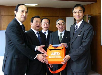 寄付したAEDを手に左から浅野会長（三条）、加藤会長（三条中央）、石崎幹事（同）、明田川会計（三条）、国定市長